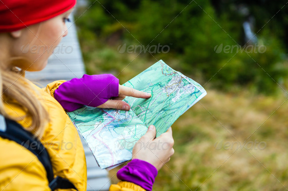 Woman hiking and reading map in forest, Karkonosze Mountains in Poland