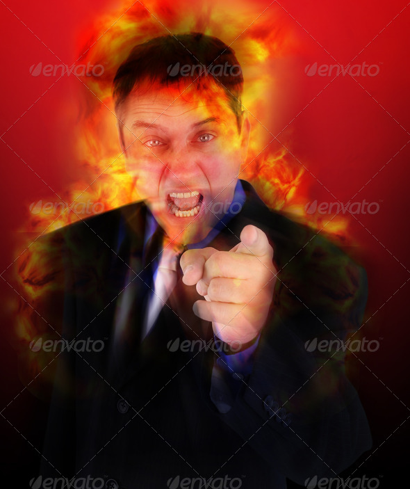 A business man boss is pointing his finger is yelling at the camera with anger and blame.