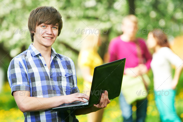 smiling young student boy with laptop