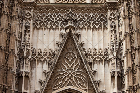 Architectural details of the 15-16th century Gothic Cathedral of Seville in Spain, exterior ornamentation above entrance door.
