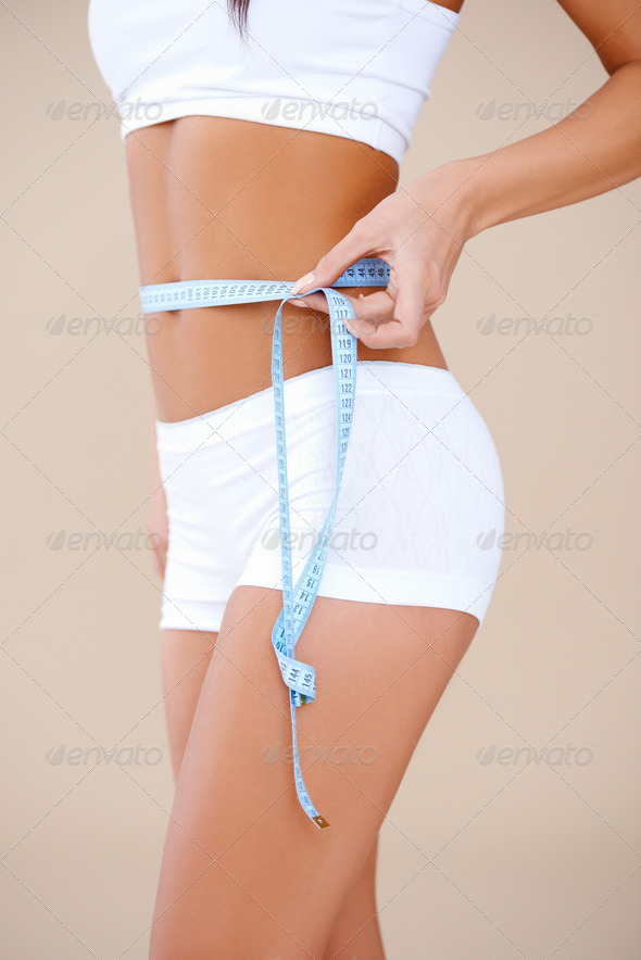 Close up of a woman she measuring her waist