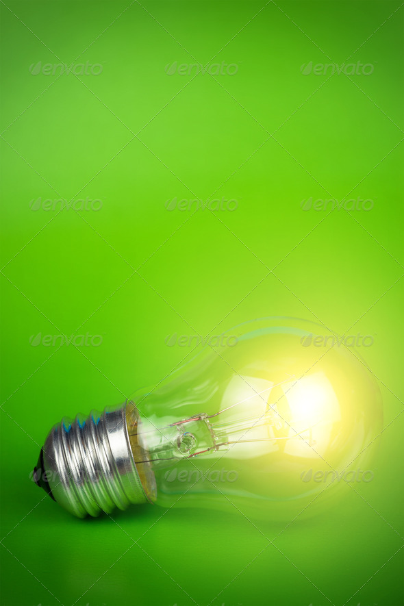 Glowing Light Bulb Over Green Background