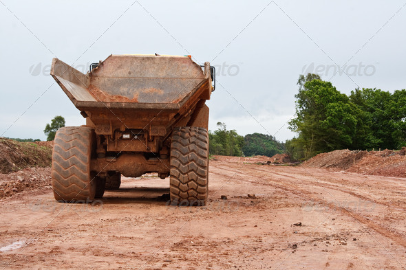 Large dump truck at a new road construction site clearing away the countryside to create a flat surface ready to lay the new dual carriageway