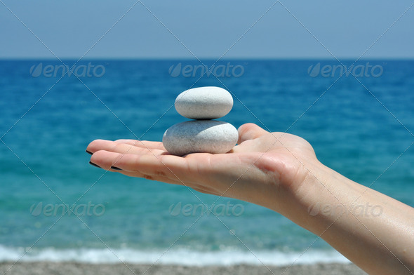 zen white round stones on woman palm good for wallpaper