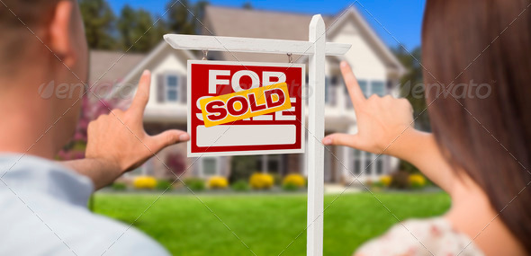 Sold For Sale Real Estate Sign, House and Military Couple Framing Hands in Front. - Stock Photo - Images