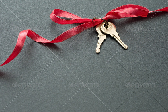 Keys with ribbon on the grey background