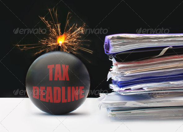 Exploding bomb labeled tax deadline next to a pile of paperwork