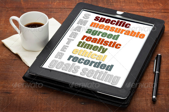 SMARTER (specific, measurable, agreed, realistic, timely, ehtical, recorded) goal setting concept on a digital tablet computer with espresso coffee