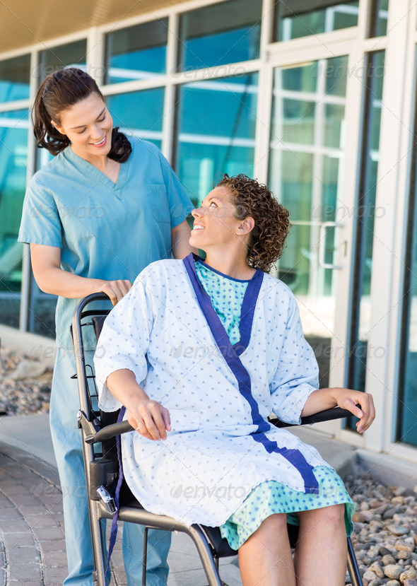 Patient Looking At Friendly Nurse While Sitting On Wheelchair