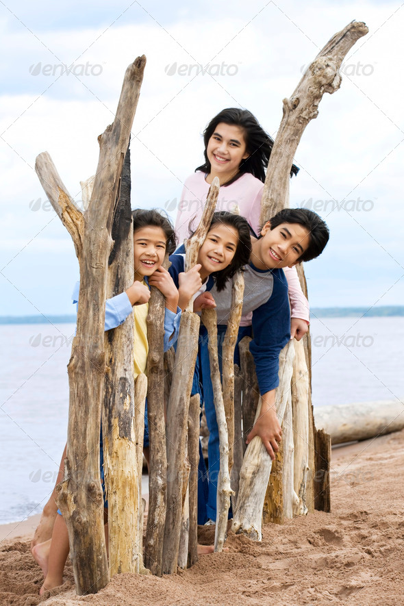 Four siblings by the lakeshore in summer, - Stock Photo - Images