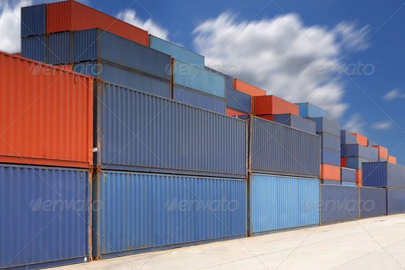 Stack of cargo containers at container yard with cloud